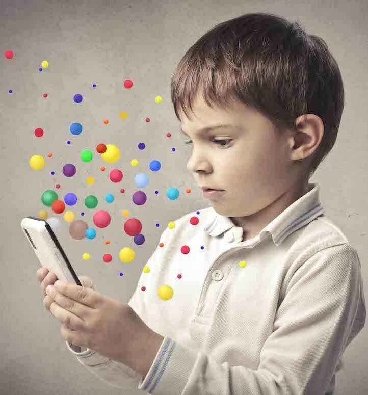 small boy looking at a phone with coloured bubbles around